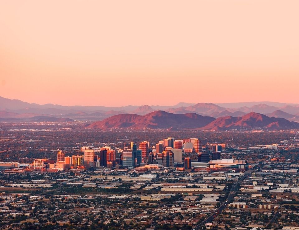 aerial view of downtown Phoenix AZ at dusk, Why are people moving out of Arizona